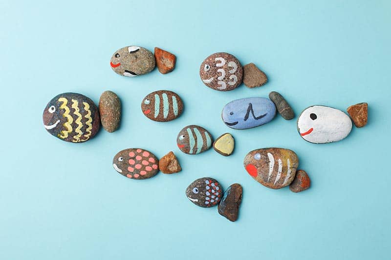 image of fish faces painted on flat rocks